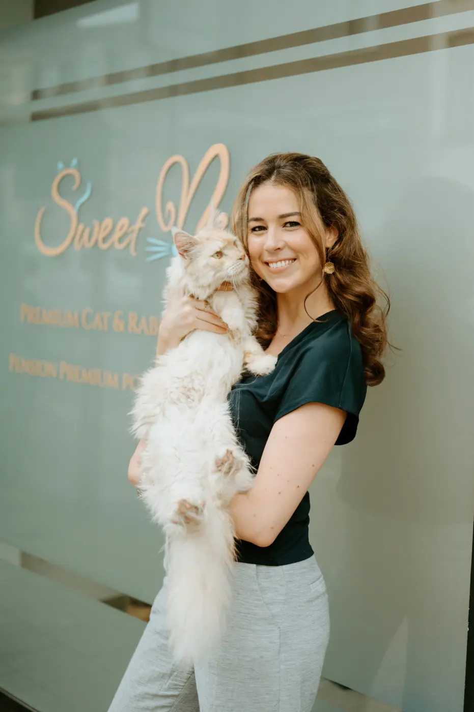 Saskia, fondatrice de Sweetnest, un chat blanc dans les bras